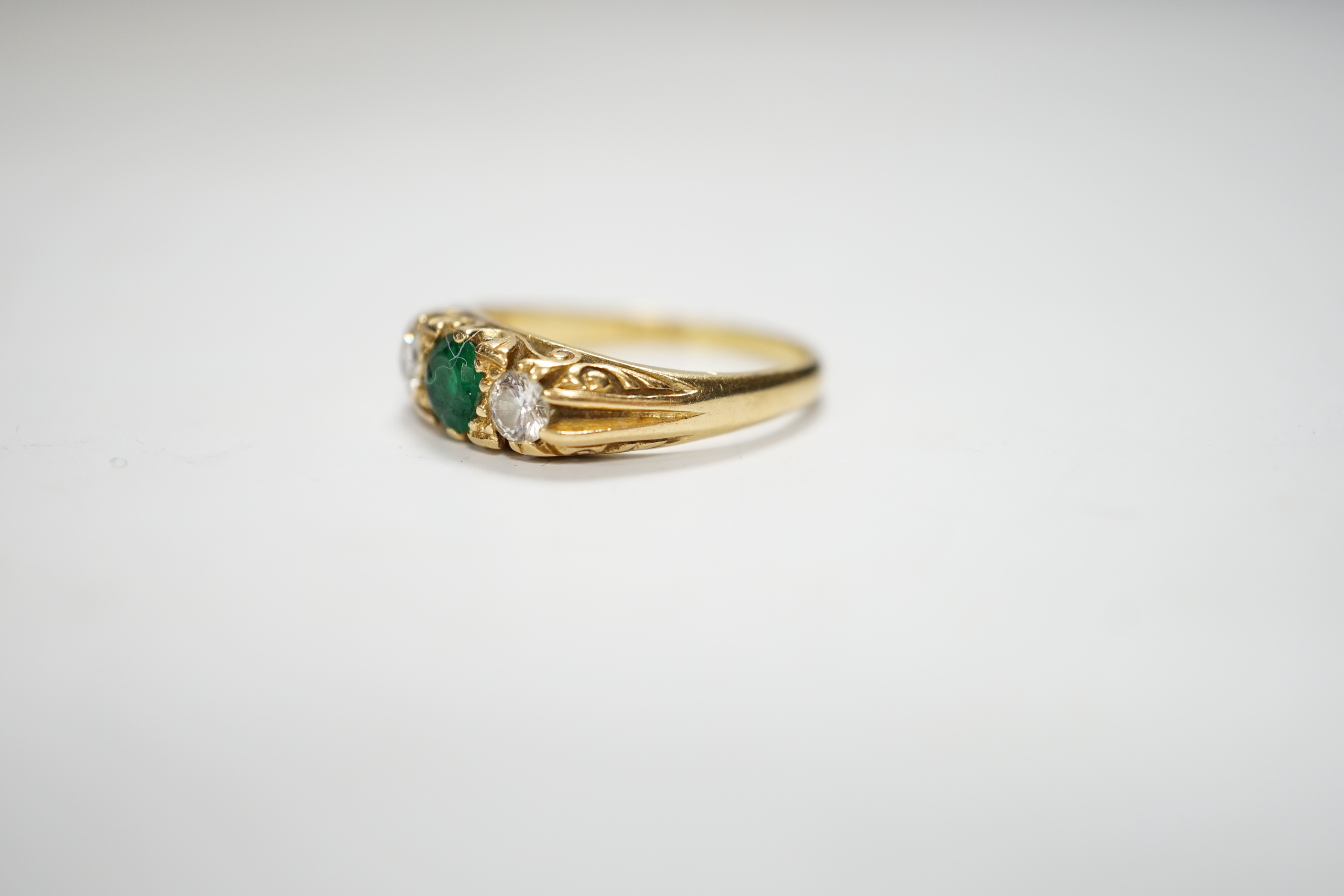 A 1970's 18ct gold emerald and diamond set three stone ring, size N/O, gross weight 4.4 grams.